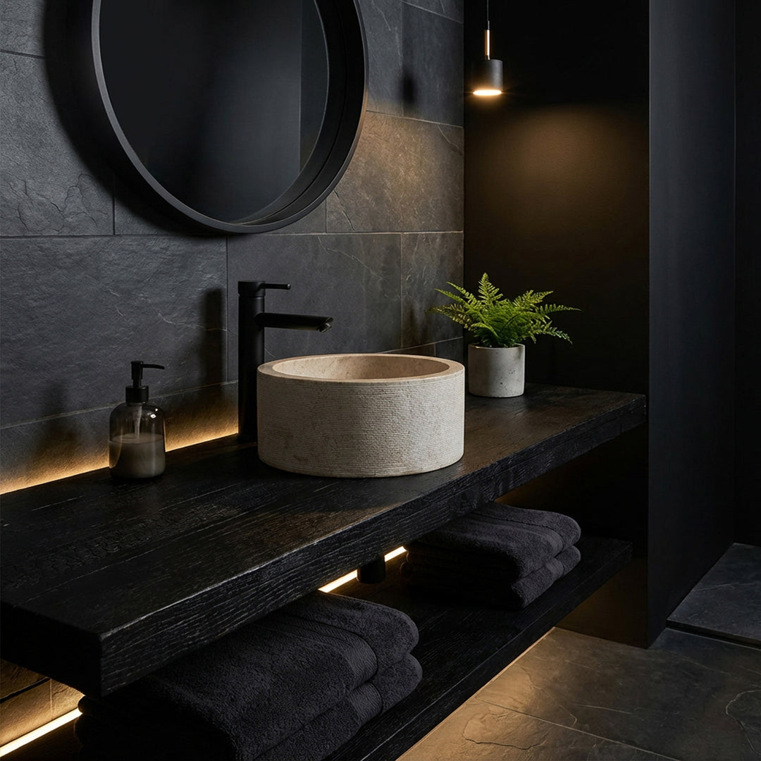 Round countertop washbasin in an elegant marble look on a dark wooden console, staged in a minimalist dark mood bathroom.