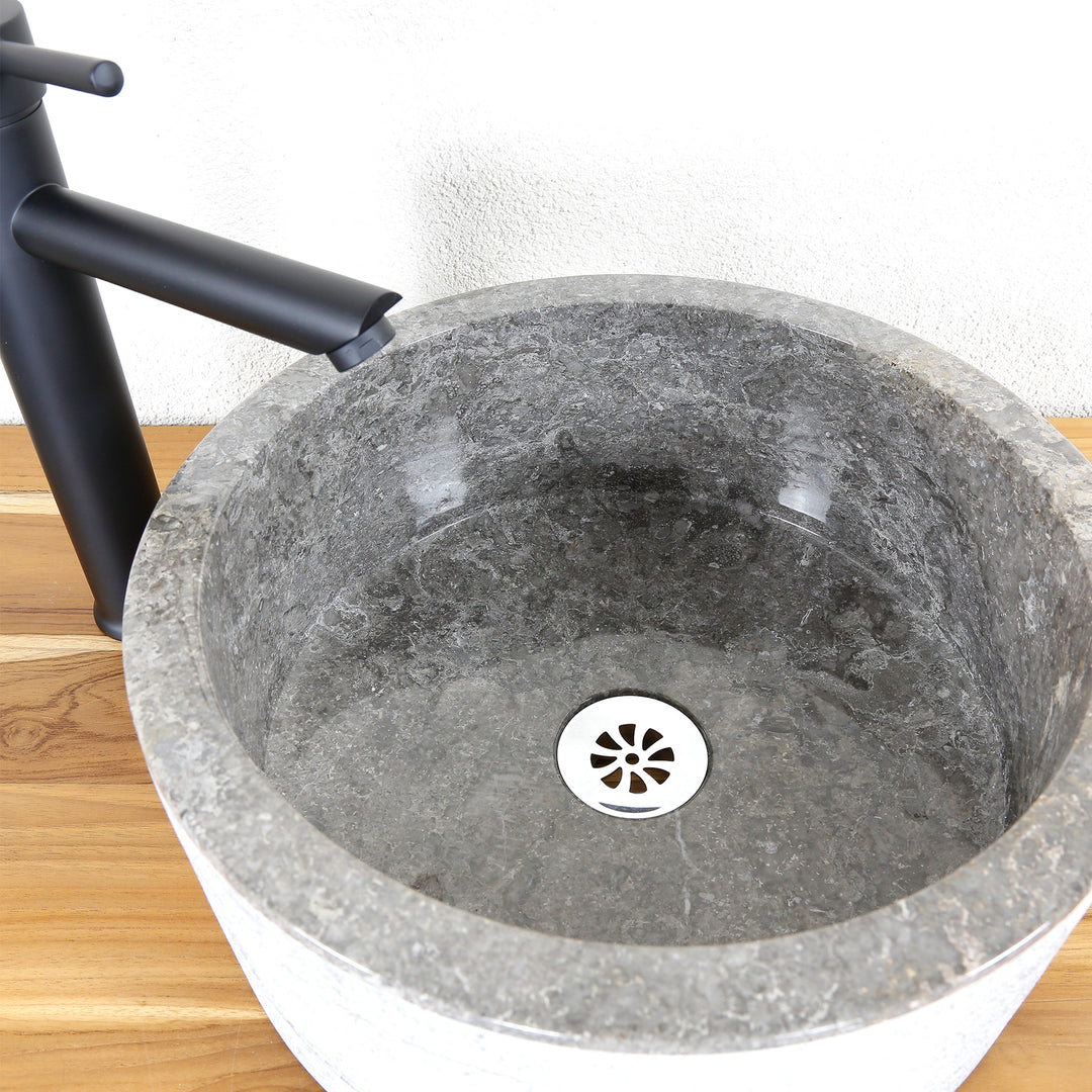 Lavabo rond en pierre avec surface finement meulée, vue détaillée de l'intérieur du lavabo et évacuation.