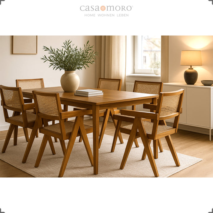 Salle à manger avec table en teck massif et fauteuils assortis en osier viennois, ambiance chaleureuse dans des tons naturels