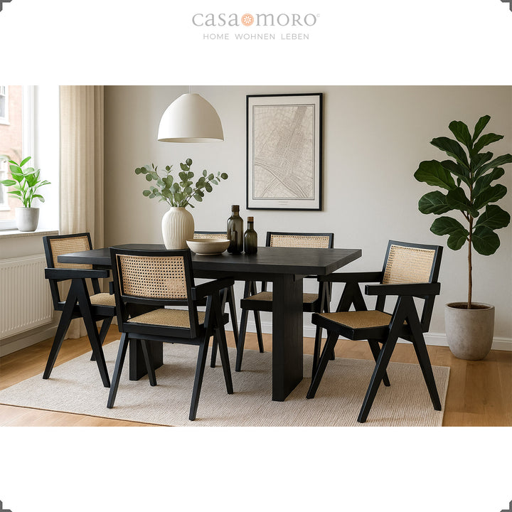 Salle à manger élégante avec fauteuils noirs en teck et osier viennois, harmonieusement combinés avec une table à manger sombre