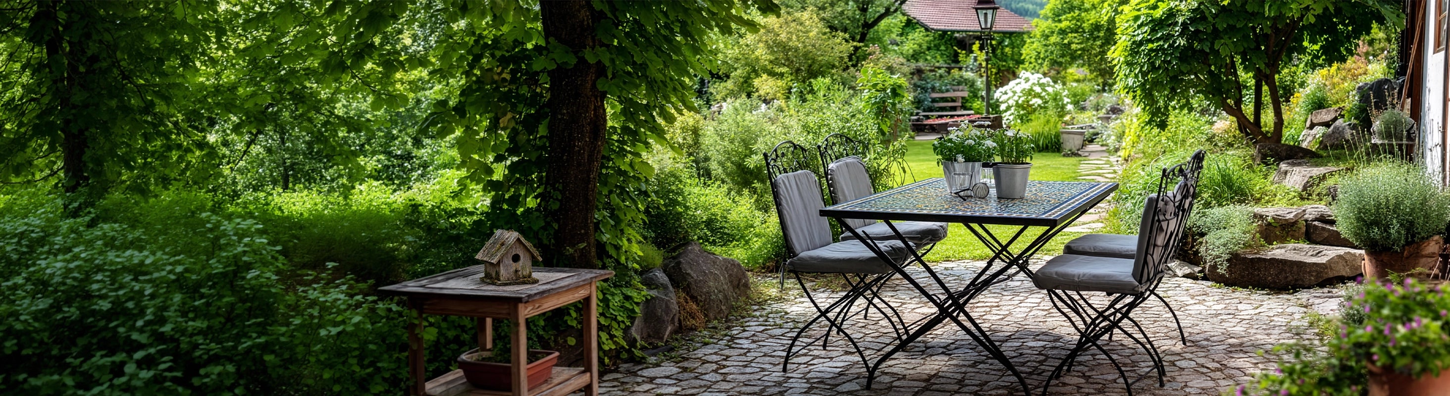Garten & Terrasse – Garten mit Mosaiktisch und Sitzgruppe auf Natursteinweg unter Bäumen – stilvoller Outdoor-Bereich für Terrasse und Gartenmöbel