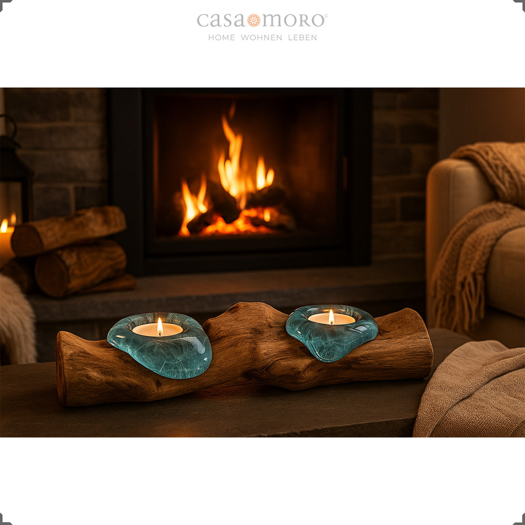 Photophore en verre et loupe devant une cheminée, sa lumière douce rehausse l'ambiance cosy du salon.