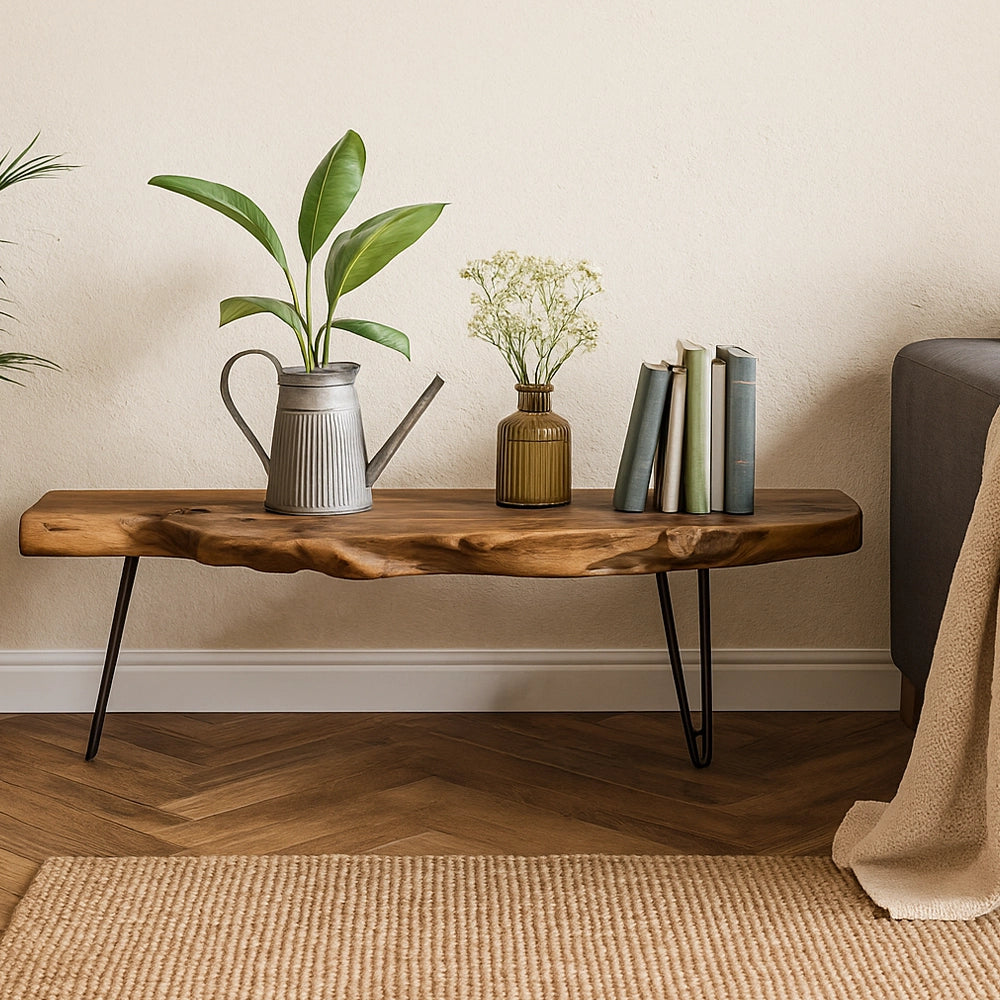 Natürliches Lowboard aus massiver Holzplatte mit filigranen Metallbeinen, dekoriert mit Pflanzen, Büchern und einer Vase im warmen Wohnzimmer.