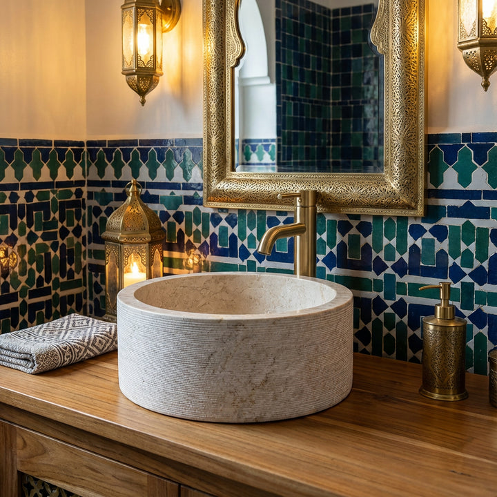 Round MarbleWashbasin on a wooden console, atmospherically staged in the oriental bathroom with mosaic tiles and brass details.
