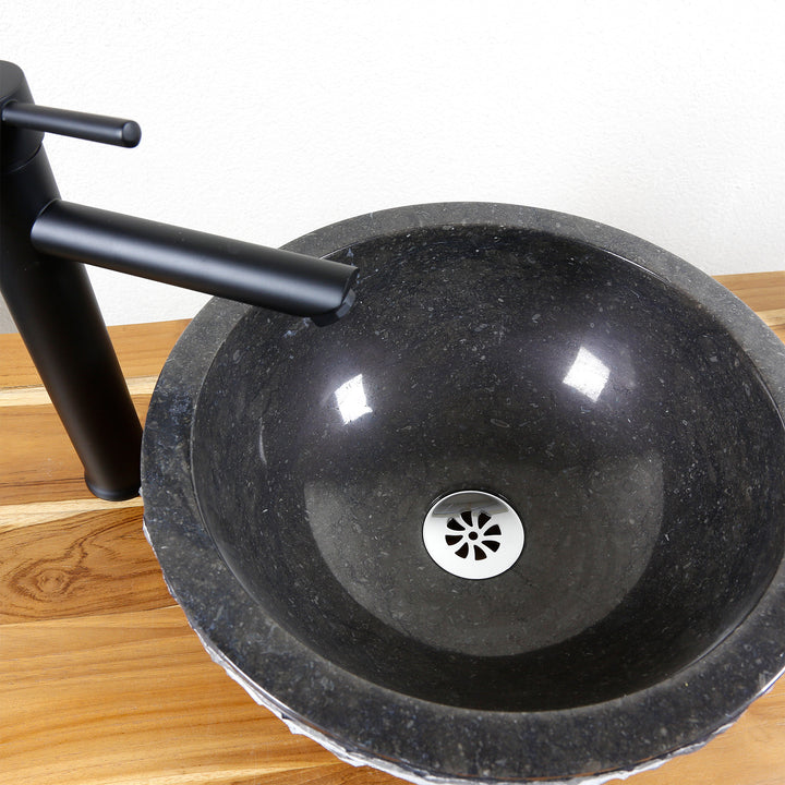 Vasque à poser ronde en pierre détaillée avec surface intérieure polie, drain en acier inoxydable et robinetterie noire