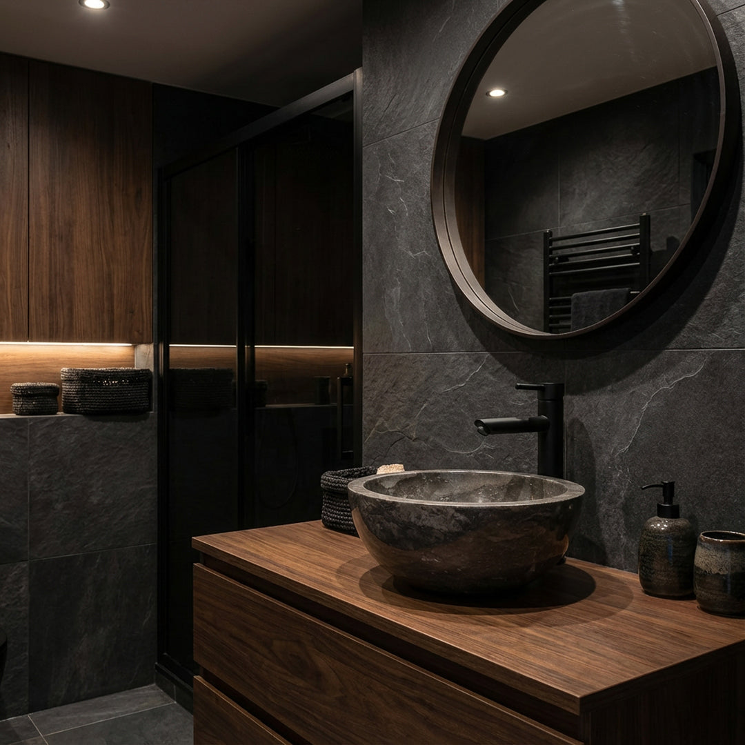 Pierre naturelle rondeLavabo comme accessoire sur un lavabo en bois sombre avec une robinetterie noire dans une ambiance de salle de bains élégante et sombre