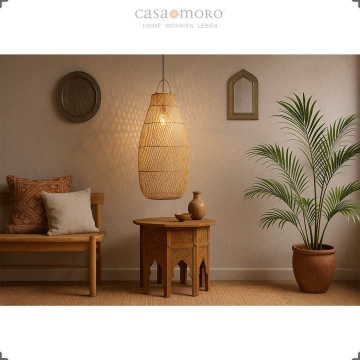 Grande lampe en rotin au-dessus de la table orientale dans le salon avec une lumière chaude et naturelle
