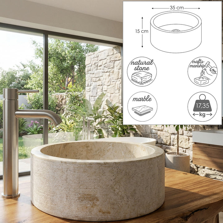 Round countertop basin made of natural stone with dimensional graphics and material symbols, presented on a wooden console in the bright bathroom.