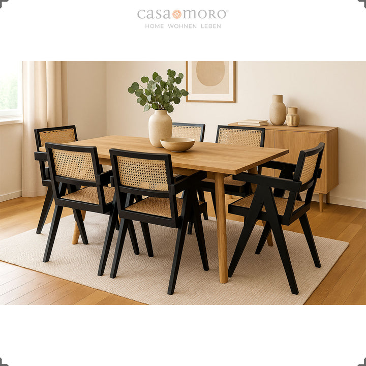 Groupe de salle à manger moderne avec fauteuils noirs en teck et osier viennois, associés à une table en bois clair