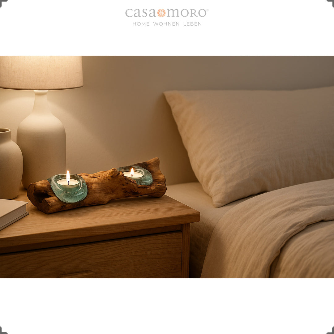 Photophore allongé en verre et bois de loupe posé sur une table de chevet, sa lumière douce crée une atmosphère apaisante dans la chambre.