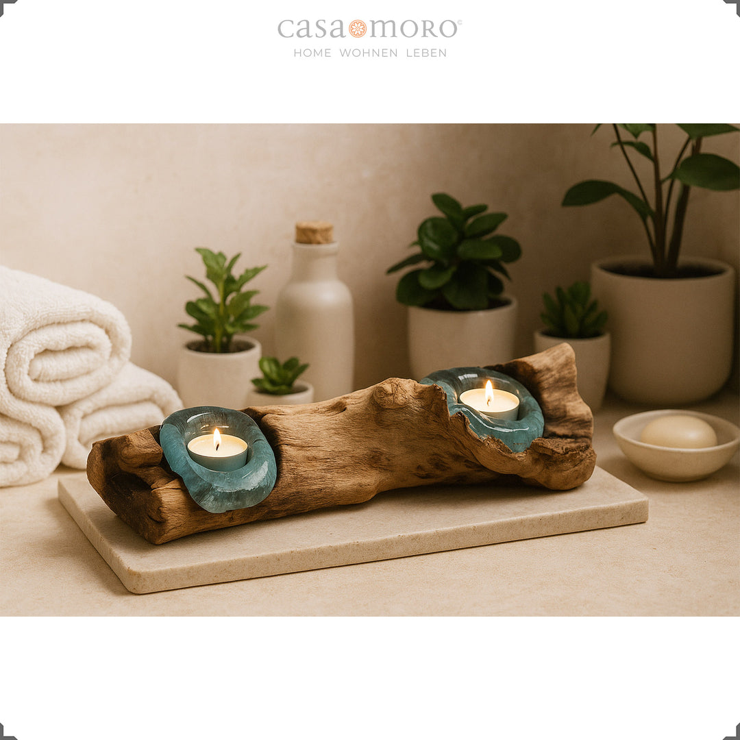 2 photophores en verre et loupe dans la salle de bain, sa lumière douce complète l'ambiance décontractée du spa avec des plantes et des serviettes.
