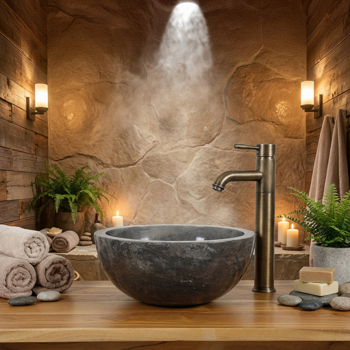 Lavabo rond en pierre monté sur une console en bois avec robinetterie en laiton dans une ambiance chaleureuse de salle de bain spa